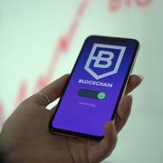 Mão segurando um smartphone que exibe uma carteira digital de criptomoedas.