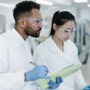 Dois cientistas realizam pesquisas em conjunto em um laboratório moderno, cercados por equipamentos científicos.