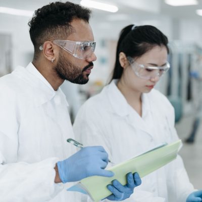 Dois cientistas realizam pesquisas em conjunto em um laboratório moderno, cercados por equipamentos científicos.